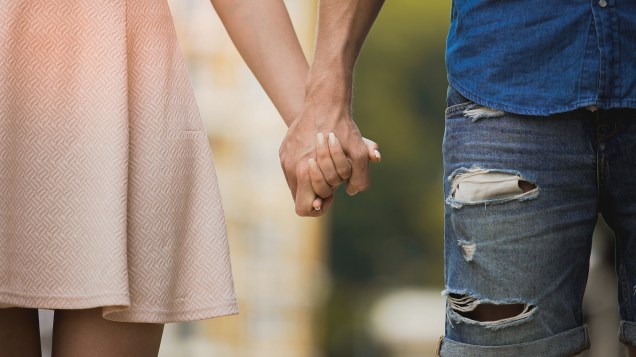 Young woman and man holding hands, tender relationship of sweet couple, love